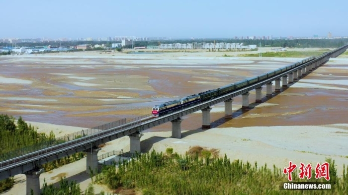 6月16日，和若铁路开通运营，首发列车穿过和田玉龙喀什河。 穆合塔尔 摄